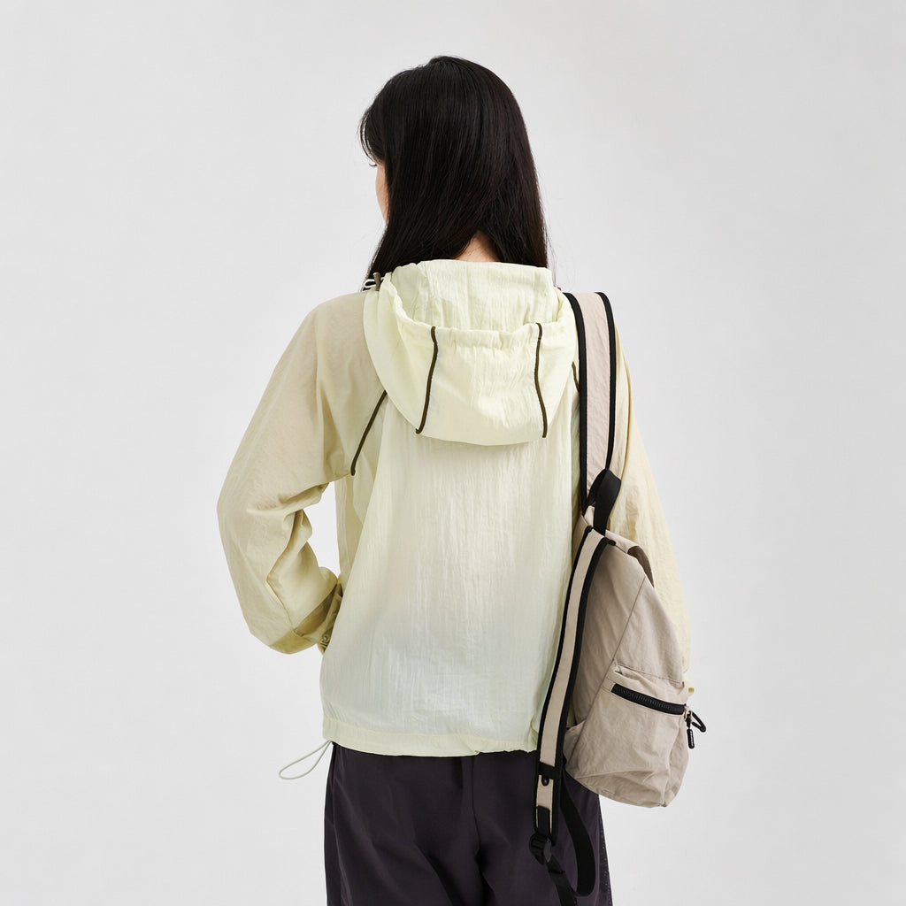 Back view of a pet parent wearing a pale green hooded sun protection jacket with a lightweight outerwear fit, designed to coordinate with dog sun jackets in pet parent matching outfits.