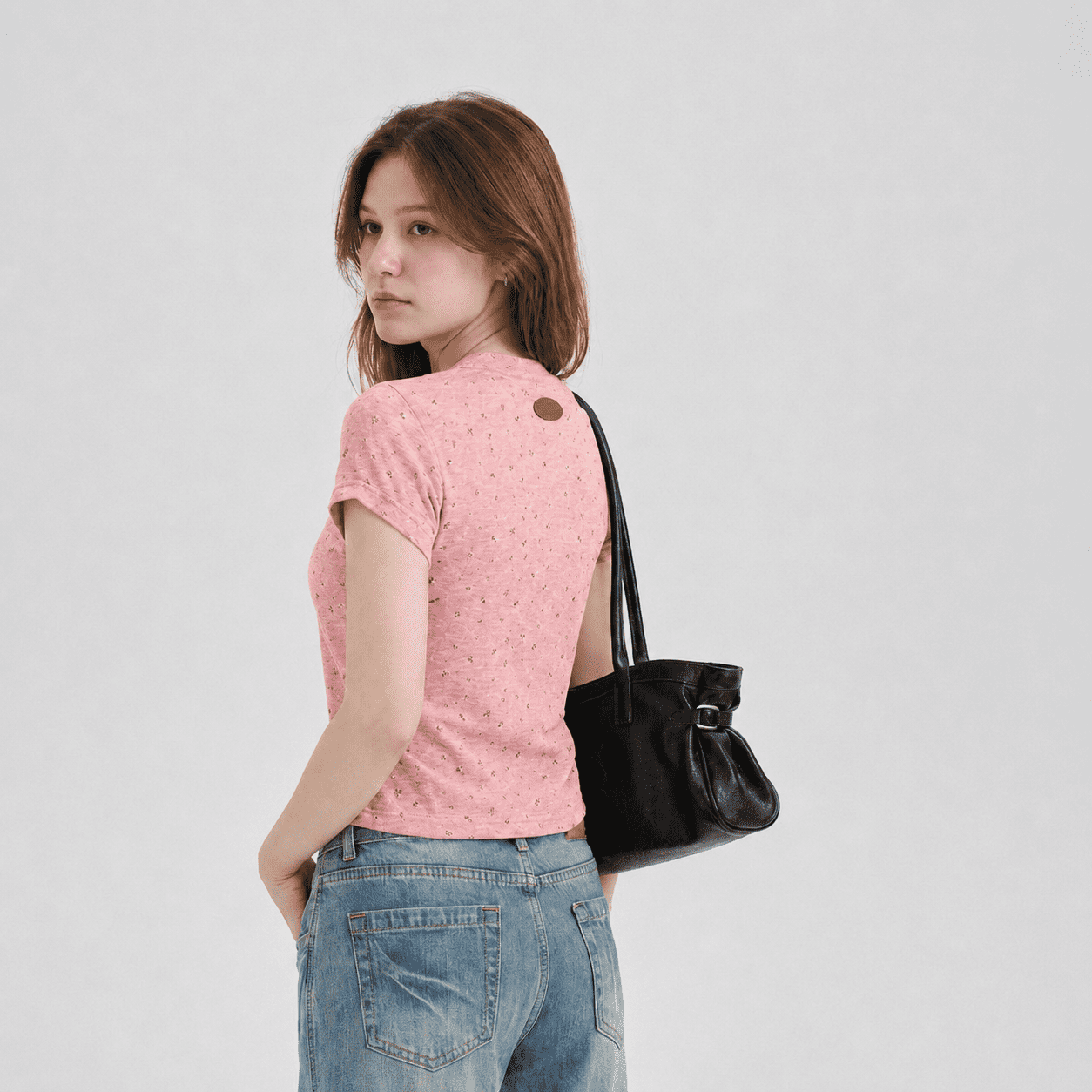 Back view of a woman wearing a pink speckled pet parent tee with a slim cropped fit and logo patch, designed as the owner top for matching pet and owner apparel.