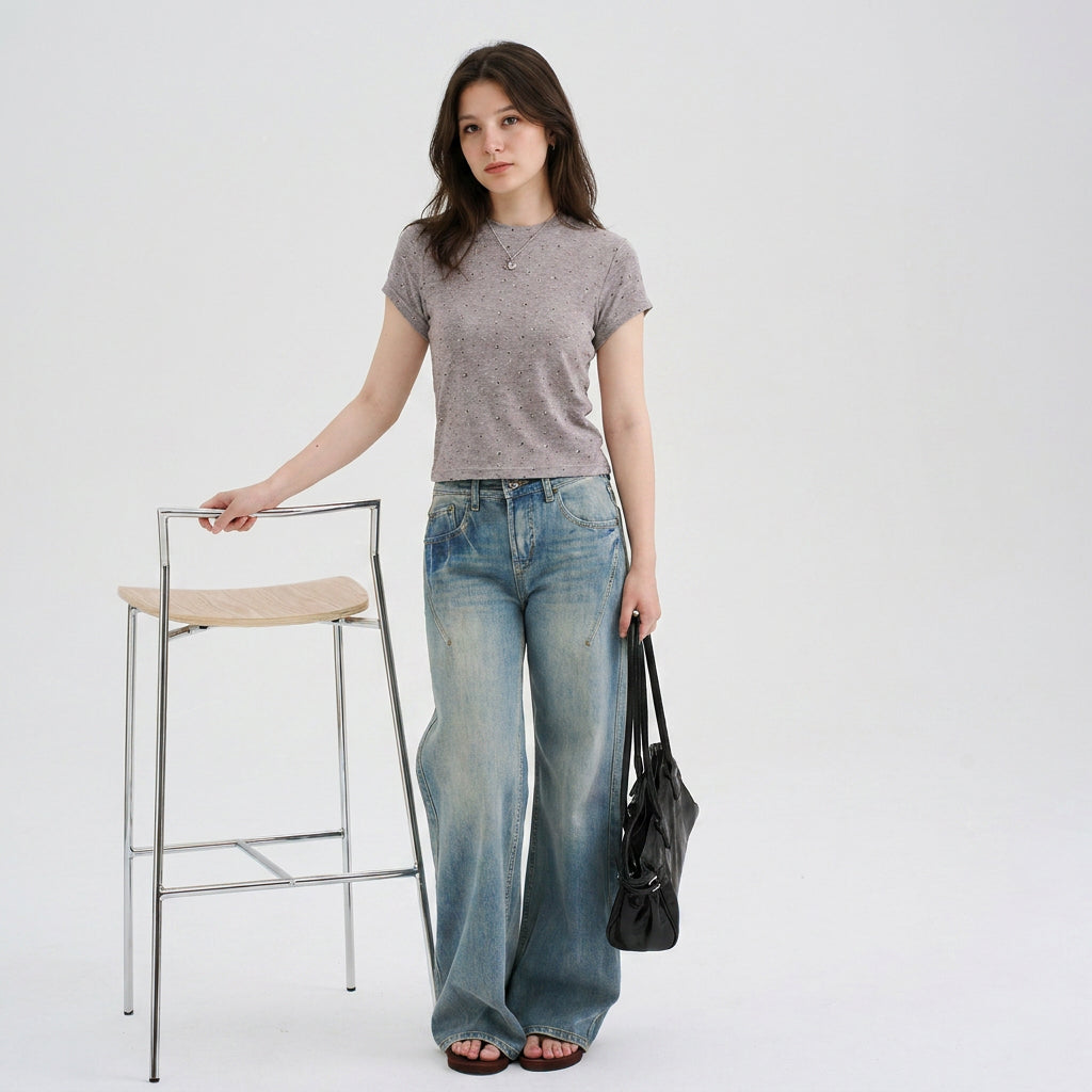 Woman wearing a gray speckled cropped pet parent tee with wide-leg jeans and a black handbag, styled as the owner top for a matching pet and owner apparel collection.