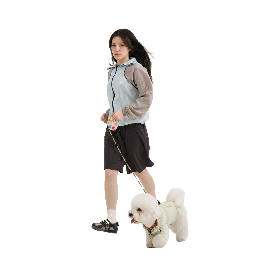 Pet parent walking a white dog in matching hooded outfits, featuring lightweight dog clothes and a casual owner jacket for everyday walks.