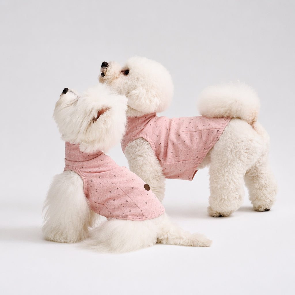 Two white small dogs wearing matching pink speckled dog tees, featuring soft dog apparel and comfortable small dog clothes for cute everyday pet clothing style.