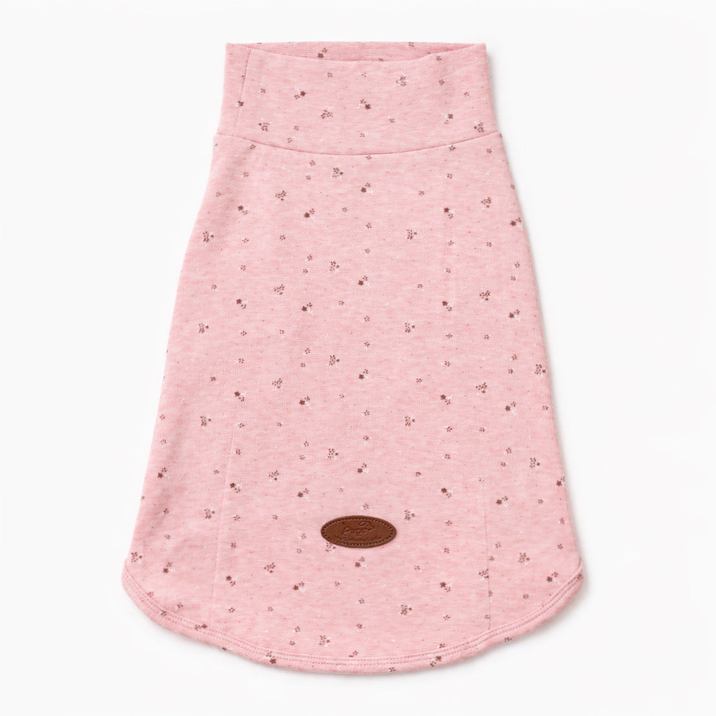 Flat lay of a pink speckled dog tee with a curved hem and leather logo patch, featuring soft dog apparel and comfortable small dog clothes for everyday pet clothing.